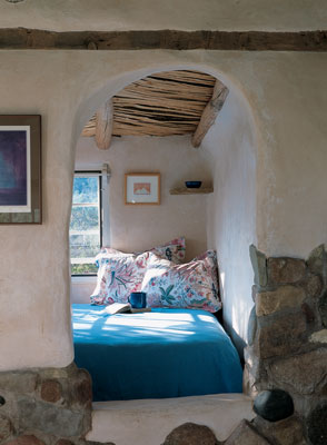 
A womb for sleeping? This bedroom, perched in an alcove, receives plenty of light, a sense of the spacious outside with an eastern view of the Pecos River, and still a snugness of enclosure within earthen walls.

